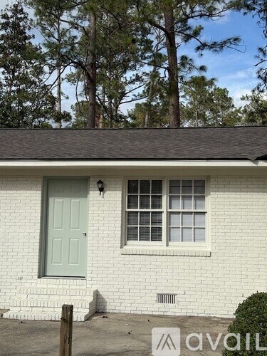 A white house with a green door and a window.