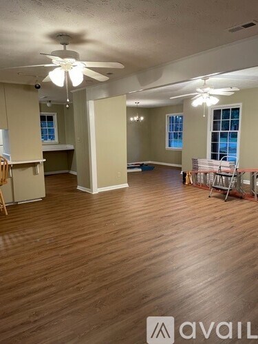 A room with wooden floors and a ceiling fan.