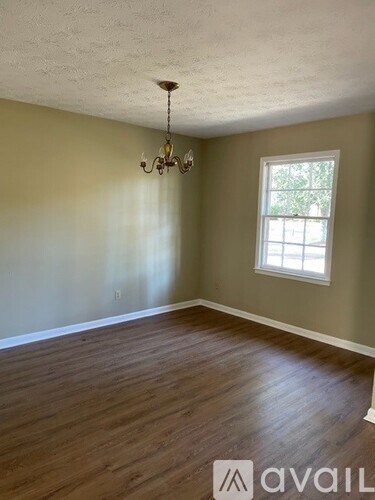 A room with wooden floors and a chandelier.