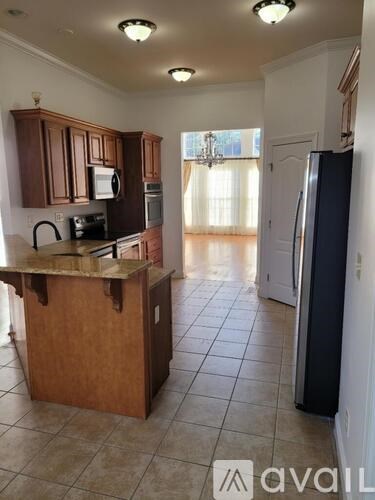 A kitchen with a wooden island and a refrigerator.