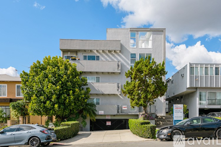 A modern building with a grey facade and a black car parked in front.