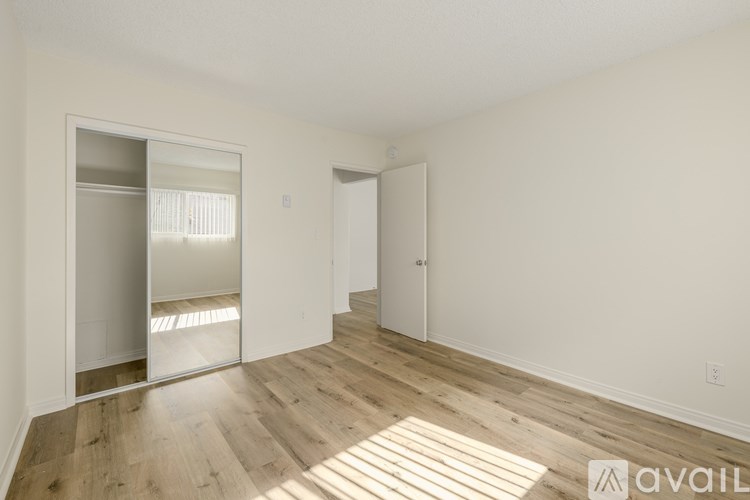 A room with wooden flooring and a large mirror on the wall.