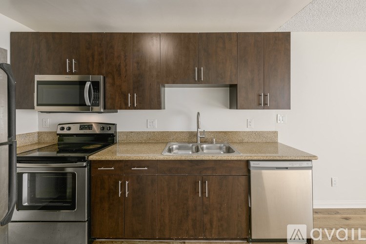 A kitchen with brown cabinets and a granite countertop.