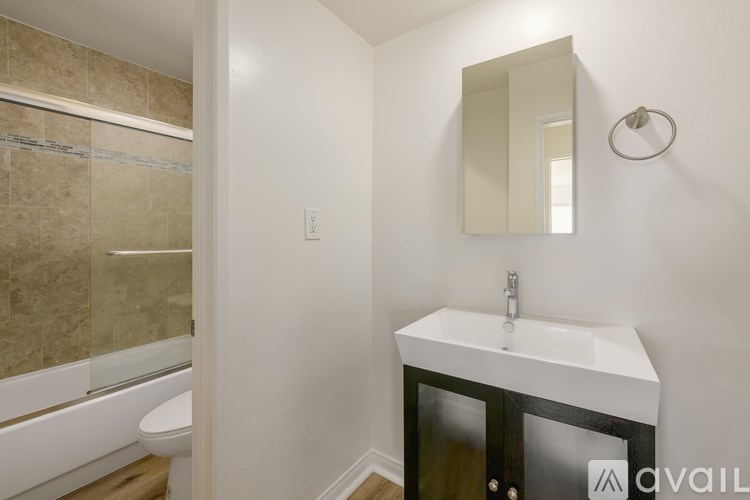 A bathroom with a sink, mirror, and bathtub.