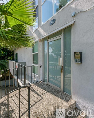 A modern house entrance with a glass door and a metal railing.
