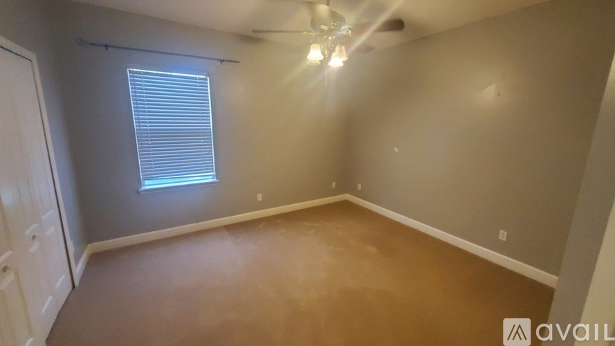 A room with a window and a ceiling fan.