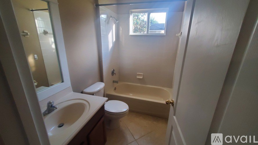 A bathroom with a toilet, sink, and bathtub.