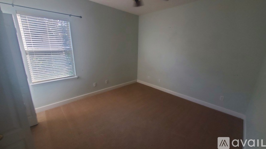 A room with a window and wooden flooring.