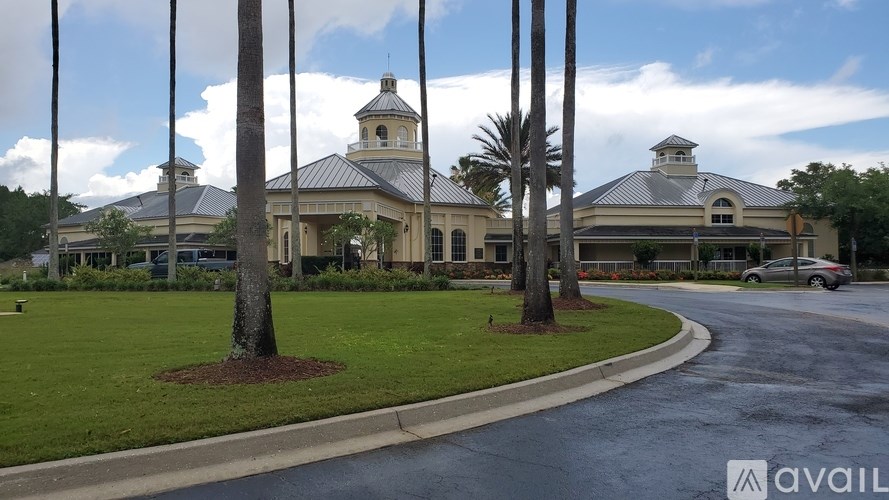 A building with a tower and a clock is surrounded by trees.