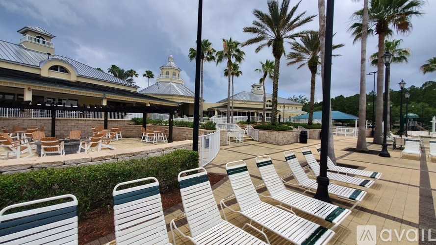 A row of white chairs are lined up on a patio.