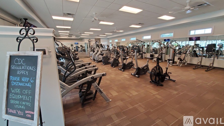 A gym with a sign that says "Regulations Apply" and "Please Keep 6 feet Distance".