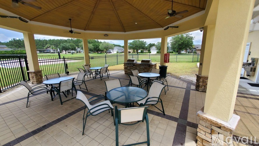 A patio with a table and chairs under a roof.