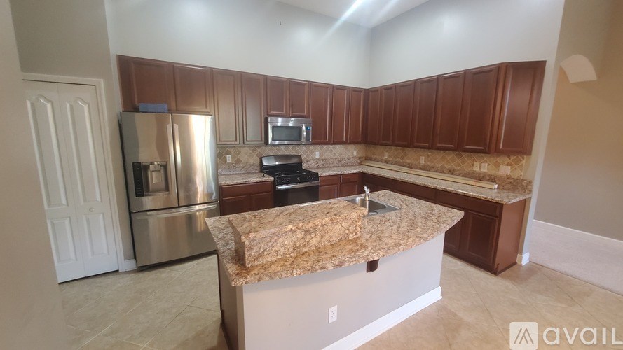 A kitchen with a granite countertop and stainless steel appliances.