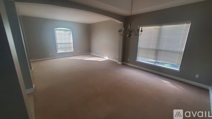 A room with a window and a chandelier is available for rent.