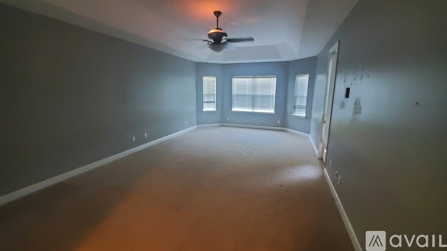 A room with a ceiling fan and a window.