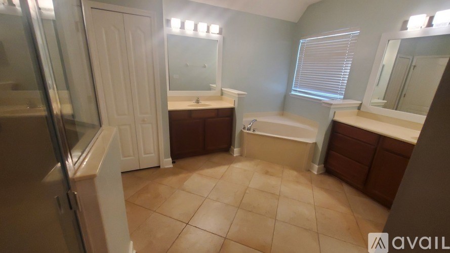 A bathroom with a large mirror, a bathtub, and a sink.