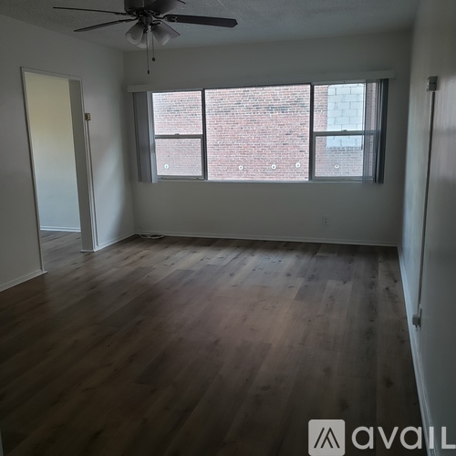 A room with a ceiling fan and wooden flooring.