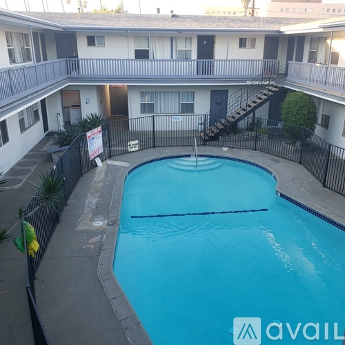 A pool surrounded by a black fence with a sign in front of it.