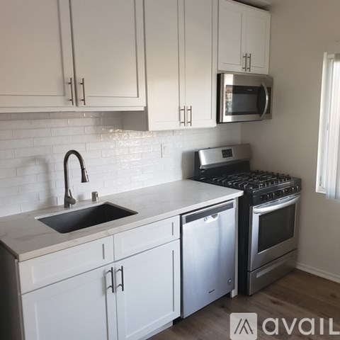 A kitchen with white cabinets and a stainless steel dishwasher.