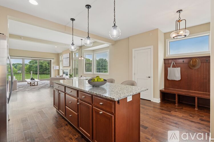A kitchen with wooden floors and a dining table with chairs.