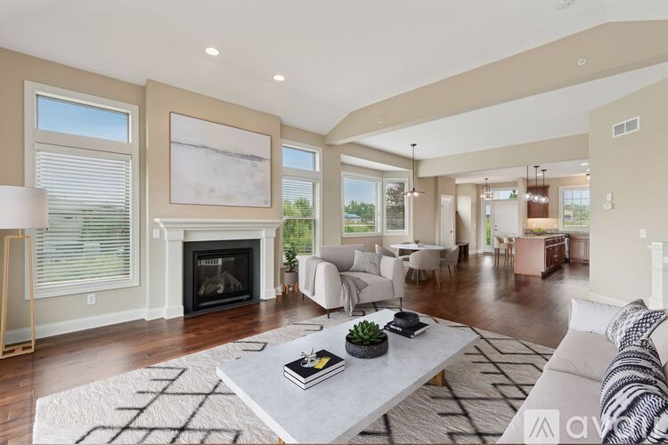A living room with a grey couch, a wooden coffee table, and a fireplace.