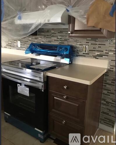 A black oven is on a counter next to a brown cabinet.
