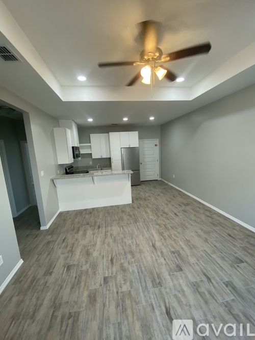 A spacious room with a ceiling fan and lighting fixtures.