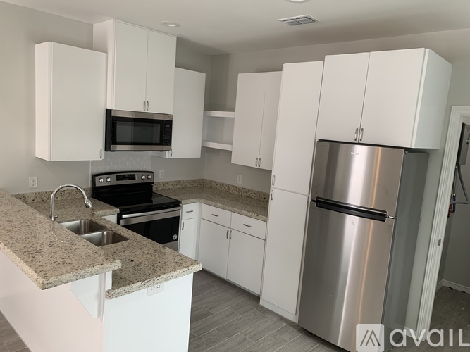 A kitchen with white cabinets and a granite countertop.