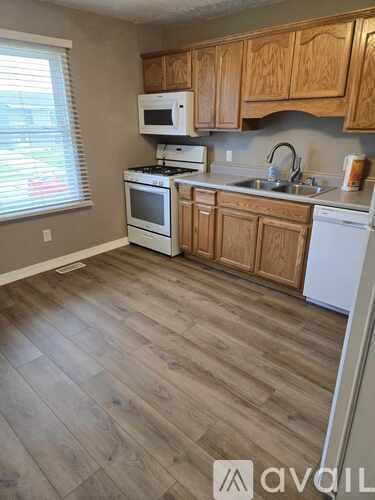 A kitchen with wooden cabinets and a white dishwasher.