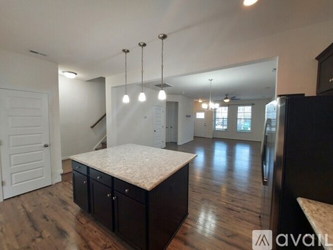 A kitchen with a marble countertop and wooden floors.