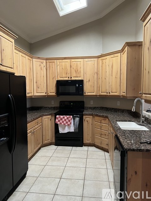 A kitchen with wooden cabinets and black appliances.