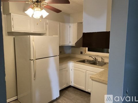 A kitchen with white appliances and cabinets.