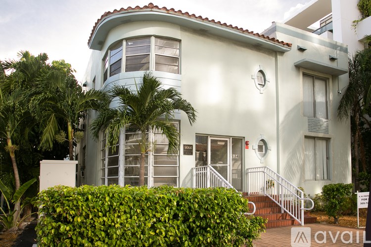 A white house with a red tile roof and a sign that says "available" in front of it.