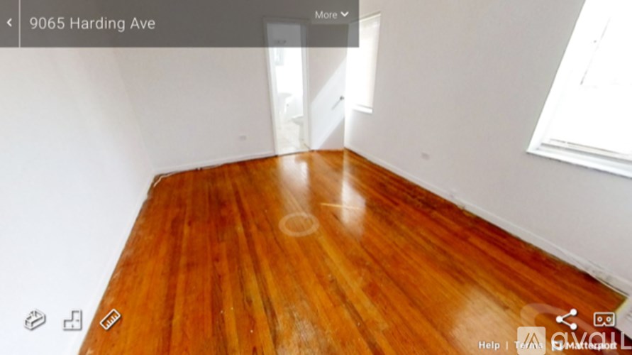 A room with wooden flooring and white walls.