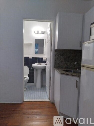 A bathroom with a toilet, sink, and mirror.