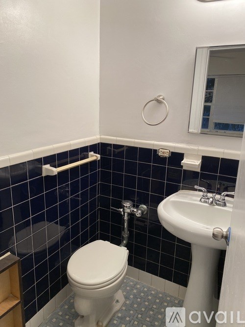 A bathroom with a toilet, sink, and mirror.