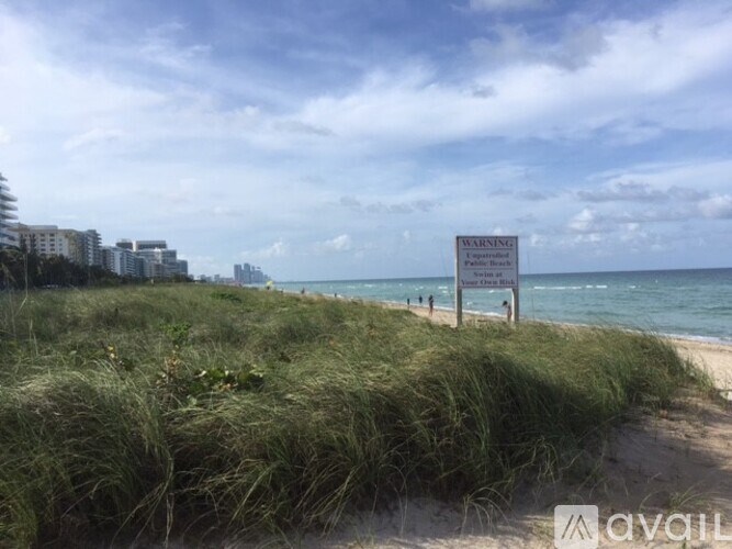 A beach with a sign that says "NO TRESPASSING" in the distance.