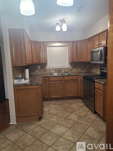 A kitchen with wooden cabinets and a tile floor.