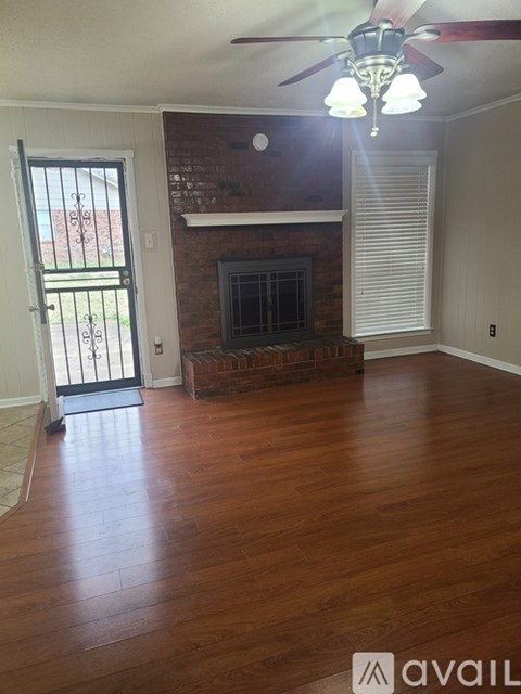 A room with a fireplace and a ceiling fan.
