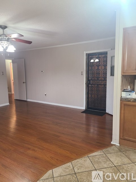 A room with wooden floors and a ceiling fan.