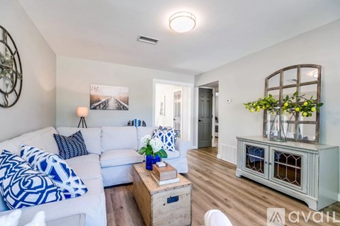 A living room with a white couch and a wooden coffee table.