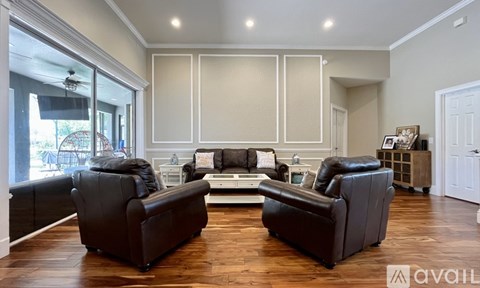 A living room with a black leather couch and a coffee table.