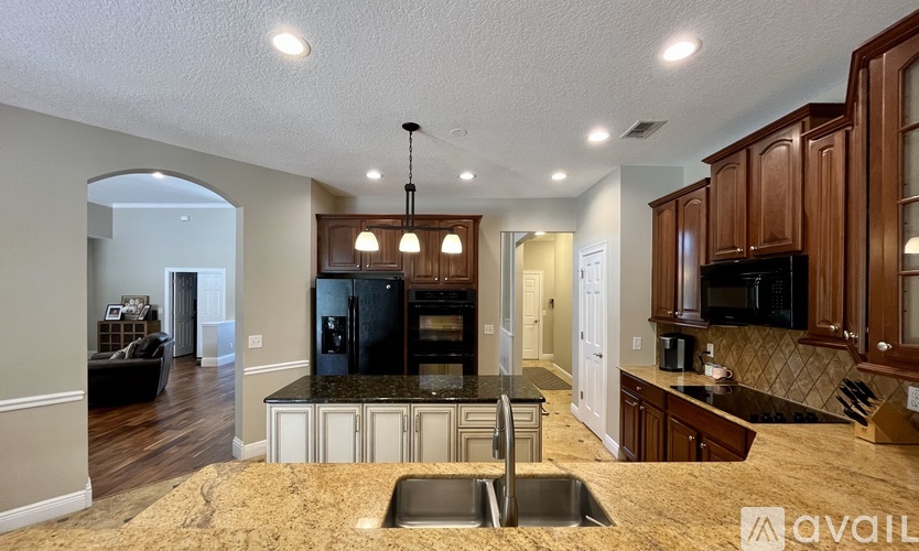 A kitchen with brown cabinets and a black countertop.