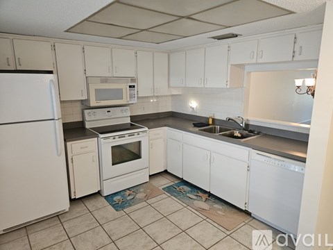 A kitchen with white cabinets and a wooden counter.