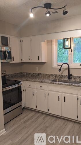 A kitchen with white cabinets and a granite countertop.