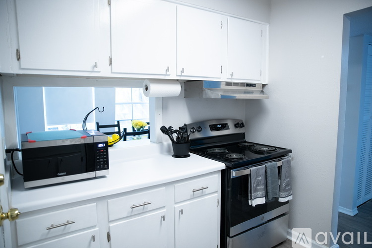 A kitchen with white cabinets and a black stove top oven.