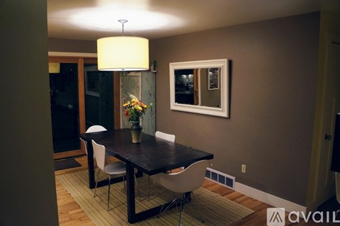 A dining room with a table and chairs.