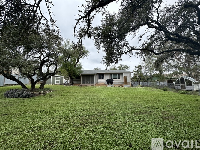 A house with a yard and trees in front of it.