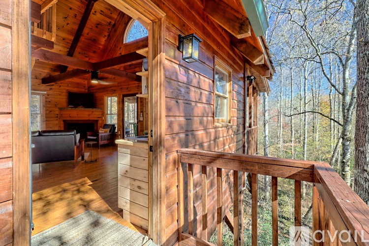 A wooden cabin with a balcony overlooking a wooded area.