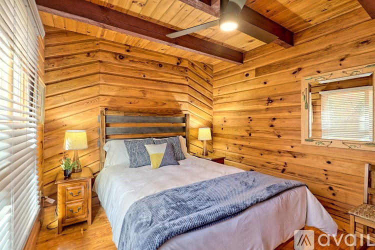 A bedroom with a bed, nightstand, and window.